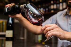 man pouring wine at wine bar